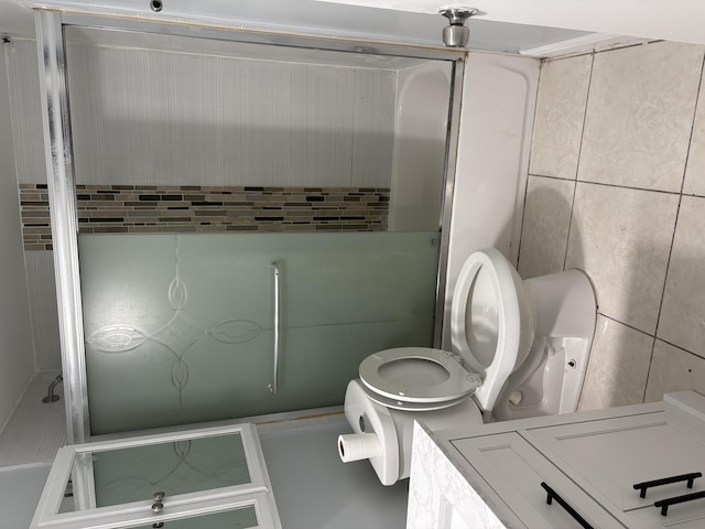 full bath featuring tile walls and toilet