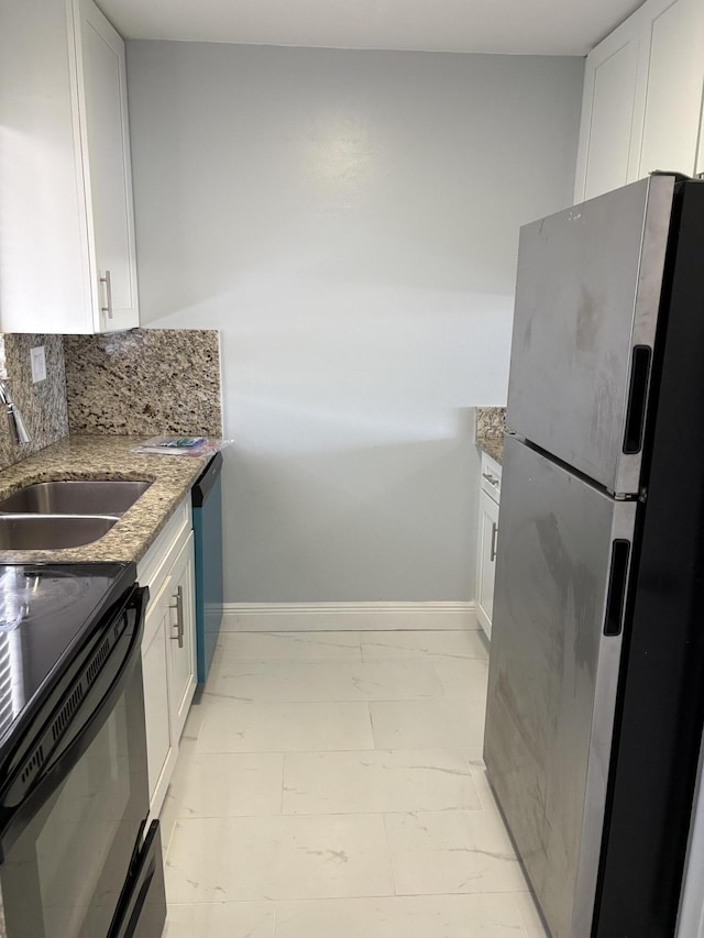 kitchen featuring a sink, light stone counters, backsplash, freestanding refrigerator, and dishwashing machine