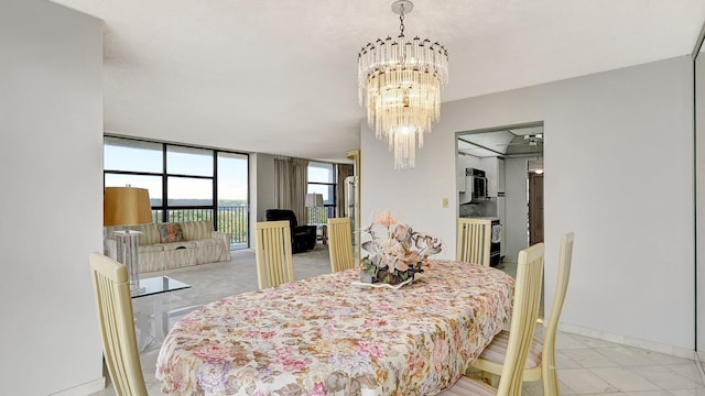 dining room with a notable chandelier and a wall of windows