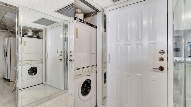 washroom with light tile patterned flooring and stacked washer / dryer