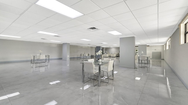 interior space featuring light tile patterned floors and a drop ceiling