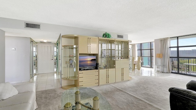 living room with floor to ceiling windows, light carpet, and a textured ceiling