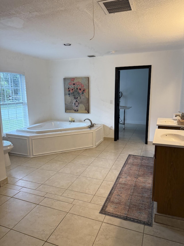 bathroom featuring tile patterned flooring, a tub, a textured ceiling, and toilet