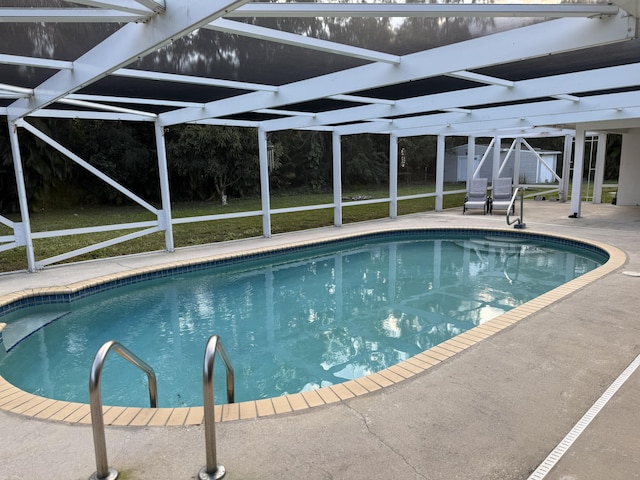 view of swimming pool featuring a lanai, a patio area, and a storage unit