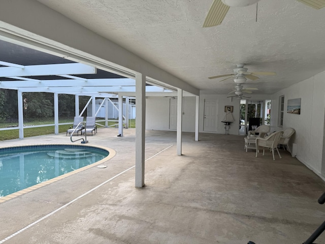 view of swimming pool with ceiling fan, a lanai, and a patio