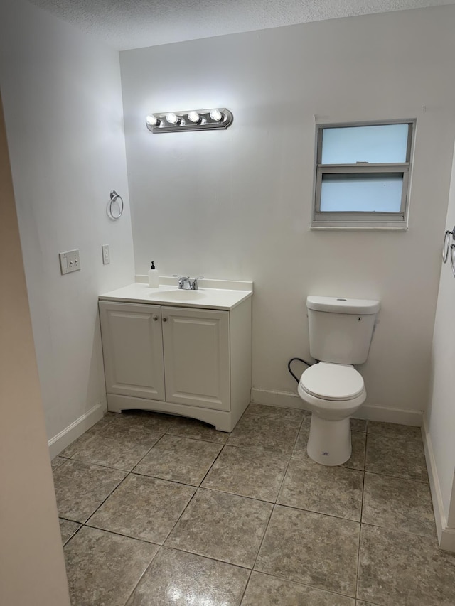 bathroom with vanity, tile patterned flooring, a textured ceiling, and toilet