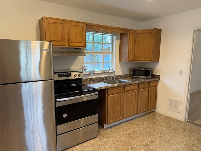 kitchen featuring light tile patterned flooring, stainless steel appliances, and sink