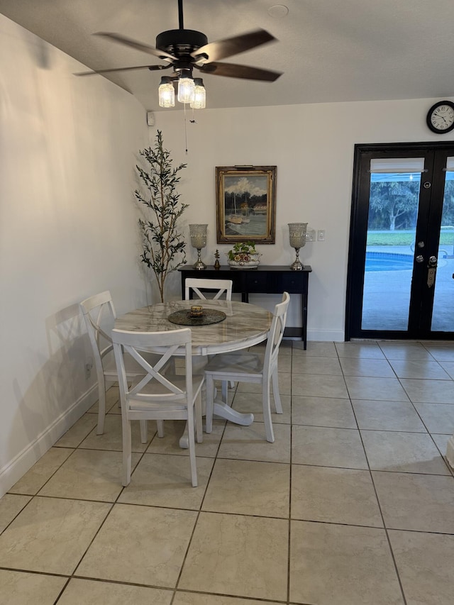 dining space with light tile patterned flooring, ceiling fan, and french doors