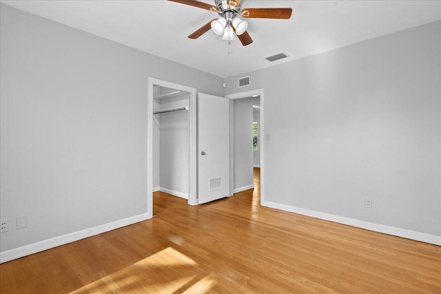 unfurnished bedroom featuring ceiling fan, light wood-type flooring, and a closet