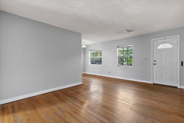 dining room featuring hardwood / wood-style flooring and a textured ceiling