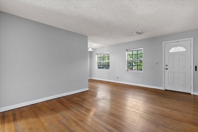 entryway with wood-type flooring and a textured ceiling