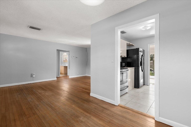 interior space featuring a textured ceiling and light wood-type flooring