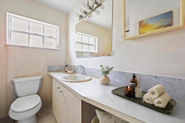 kitchen with white cabinetry, sink, light tile patterned floors, and stainless steel dishwasher