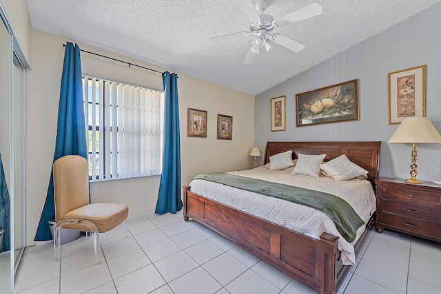 tiled bedroom with ceiling fan, lofted ceiling, and a textured ceiling