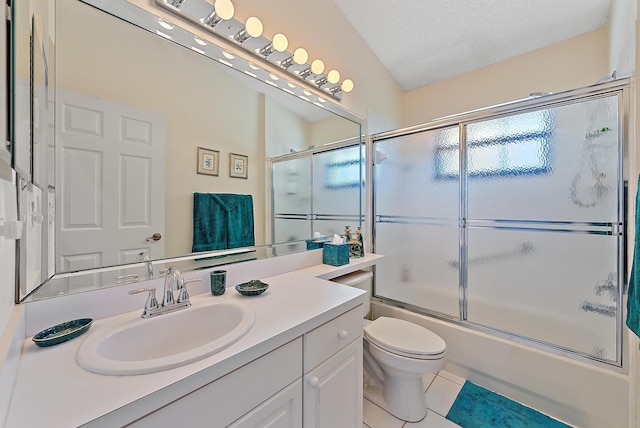 full bathroom with combined bath / shower with glass door, vanity, toilet, tile patterned floors, and a textured ceiling