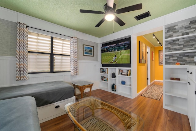 bedroom featuring ceiling fan, wood-type flooring, and a textured ceiling