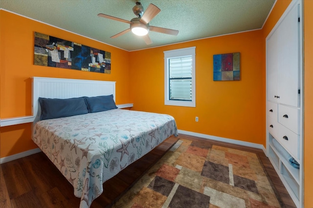 bedroom featuring ceiling fan, dark wood-type flooring, and a textured ceiling