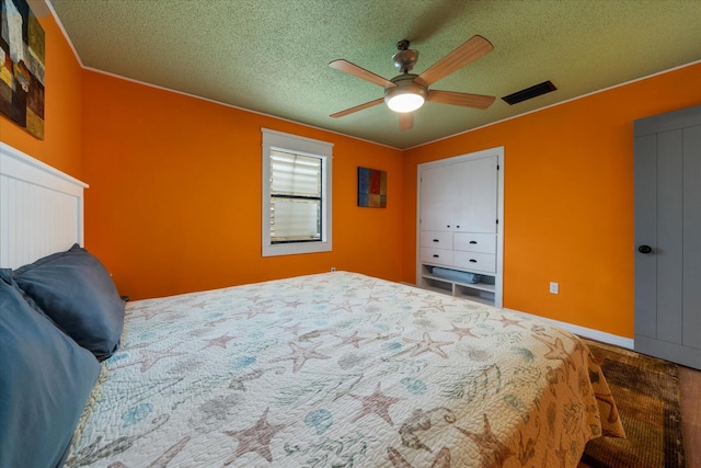 bedroom featuring ceiling fan and a textured ceiling