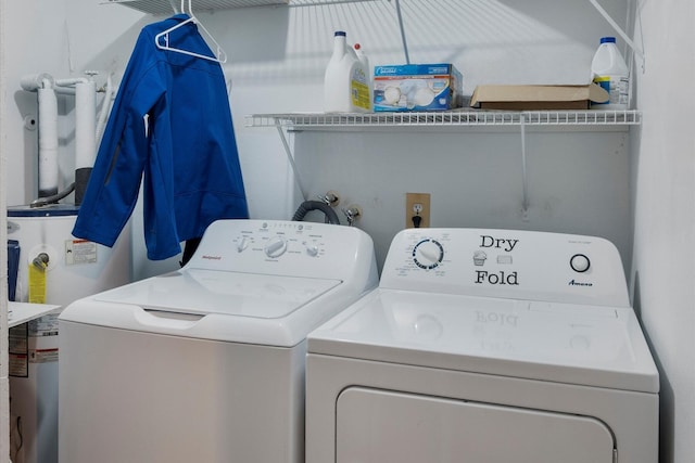 clothes washing area with washing machine and clothes dryer and electric water heater