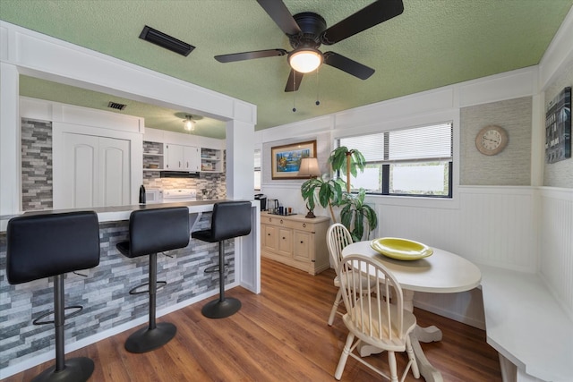 dining area with hardwood / wood-style flooring and a textured ceiling