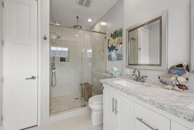 bathroom featuring vanity, toilet, and a shower with shower door