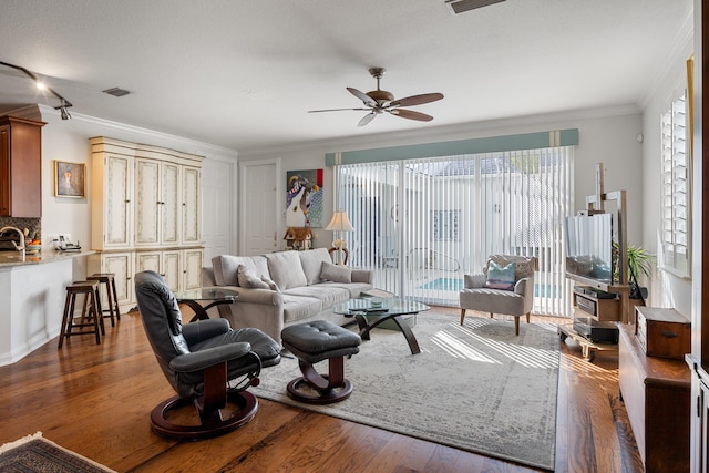 living room with ceiling fan, ornamental molding, and dark hardwood / wood-style flooring