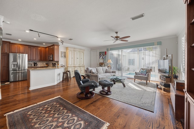 living room featuring ornamental molding, dark wood-type flooring, ceiling fan, and a textured ceiling