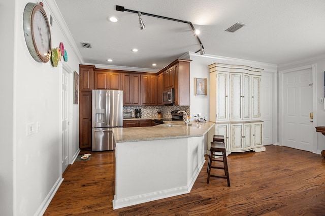 kitchen with sink, dark wood-type flooring, stainless steel appliances, and kitchen peninsula