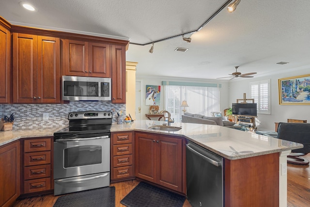 kitchen featuring stainless steel appliances, kitchen peninsula, and sink