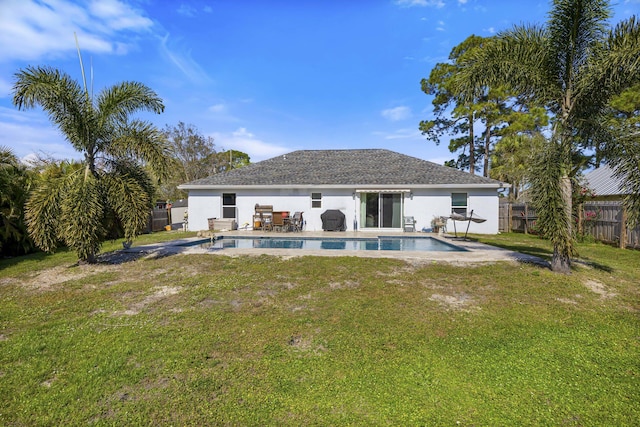 rear view of house featuring a fenced in pool, a patio, and a lawn