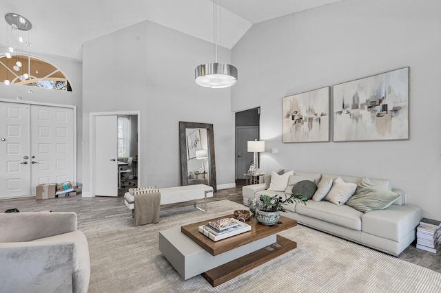 living room featuring a chandelier, high vaulted ceiling, and hardwood / wood-style floors