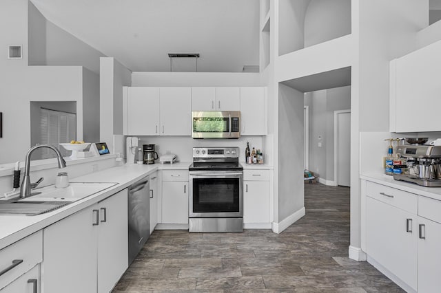 kitchen with sink, white cabinets, and appliances with stainless steel finishes