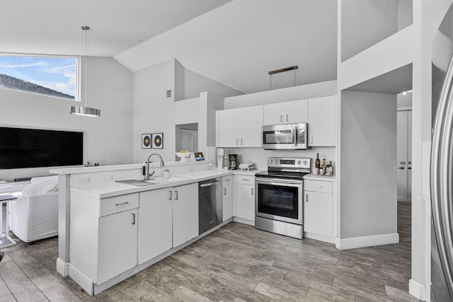 kitchen featuring white cabinetry, sink, kitchen peninsula, and appliances with stainless steel finishes