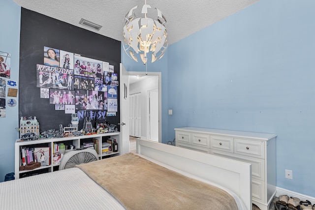 bedroom with a textured ceiling and a chandelier