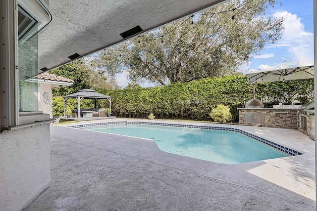 view of pool with a gazebo, a patio, and exterior kitchen