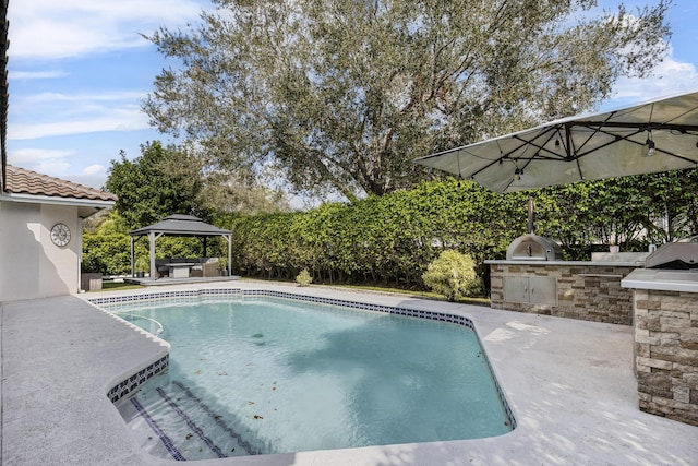 view of swimming pool featuring area for grilling, a gazebo, and a patio