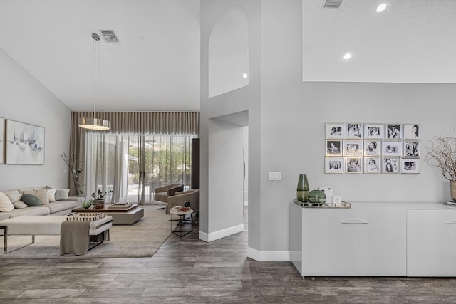 living room with hardwood / wood-style floors and a towering ceiling