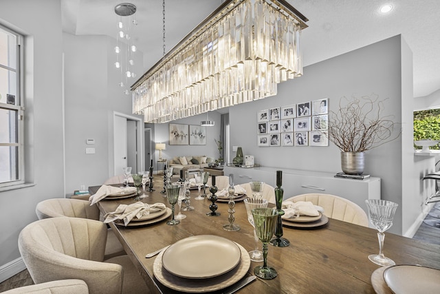 dining room featuring an inviting chandelier and a towering ceiling