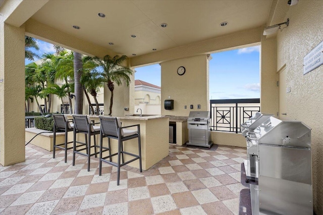 view of patio / terrace featuring a grill, an outdoor kitchen, and an outdoor wet bar