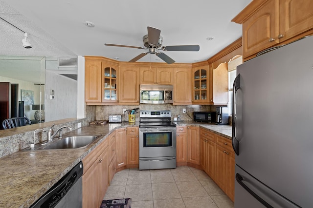 kitchen with sink, backsplash, light tile patterned floors, ceiling fan, and stainless steel appliances