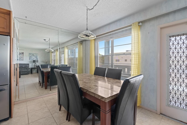 tiled dining space with a textured ceiling