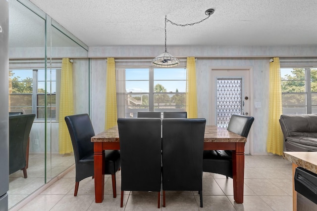 dining space with plenty of natural light, a textured ceiling, and light tile patterned flooring