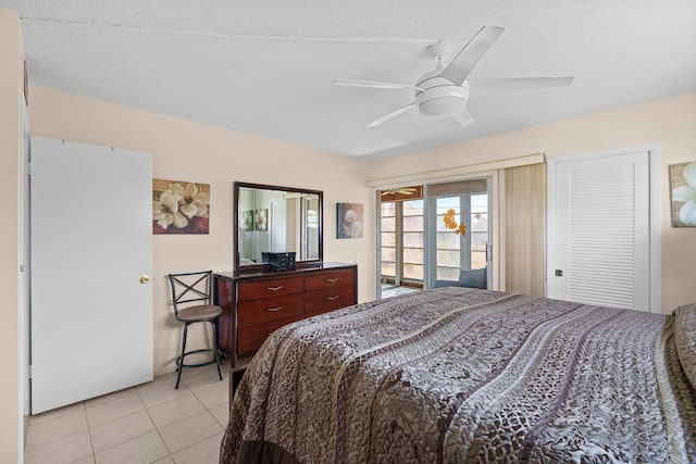 tiled bedroom with access to exterior, a textured ceiling, and ceiling fan