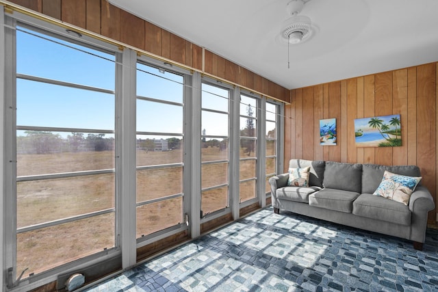 sunroom / solarium with ceiling fan, a rural view, and a wealth of natural light