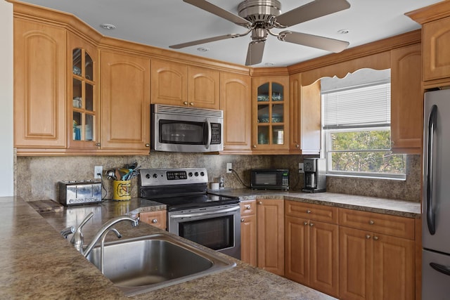 kitchen with appliances with stainless steel finishes, sink, ceiling fan, and decorative backsplash