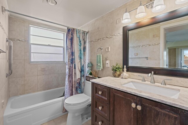 full bathroom with tile patterned floors, toilet, tile walls, and a wealth of natural light