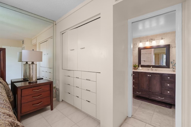 interior space featuring sink, light tile patterned floors, and a textured ceiling