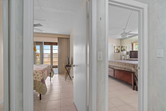 bedroom with access to outside, light tile patterned floors, multiple windows, and a textured ceiling