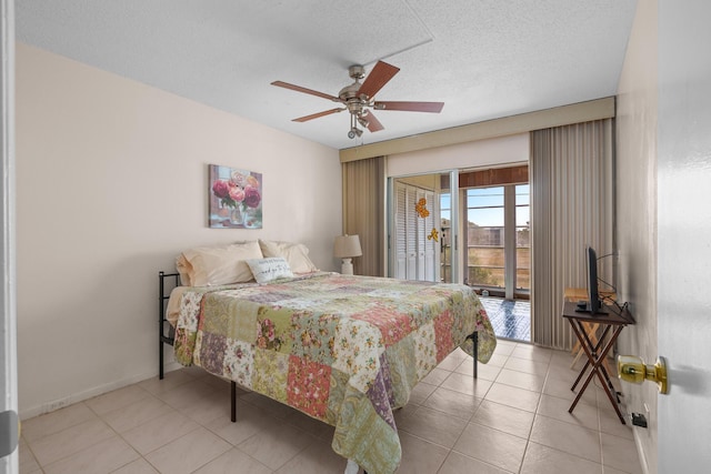 tiled bedroom with ceiling fan, access to exterior, and a textured ceiling