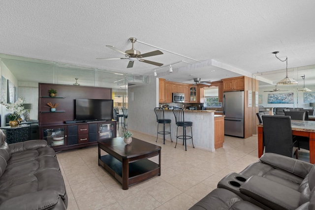 tiled living room featuring ceiling fan and a textured ceiling